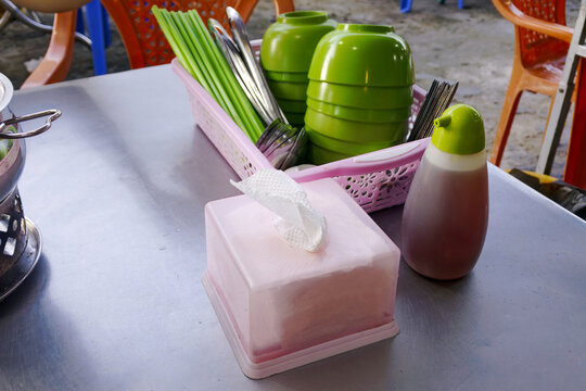 Traditional Vietnamese street food eatery table setup featuring green plastic bowls bat dua nhua and chopsticks