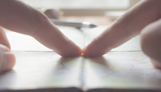 Close-Up of Fingers Pointing at a Map