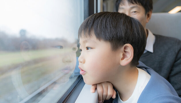 Young Boy Looking Out of Train Window with Reflection