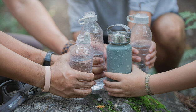 Group of People Sharing Water Bottles in Nature