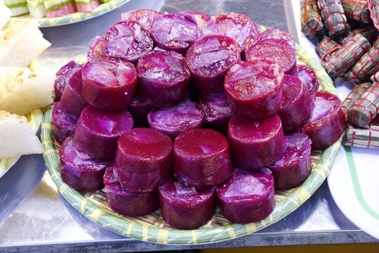 Vibrant purple yam cake, Banh Khoai Mon, stacked on a tray, showcasing traditional Vietnamese dessert culture.