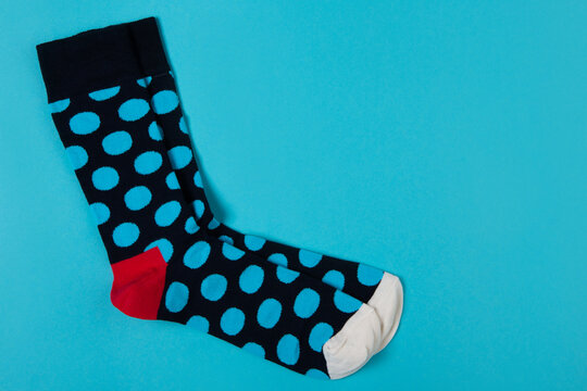 Pair of blue polka dot socks on bright blue background with copy space. Funny colorful casual hosiery top view