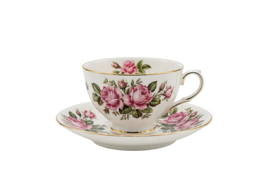 A classic white porcelain teacup and saucer set decorated with a delicate pink rose floral pattern and gold rim details on a black background