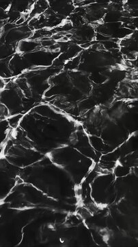 A serene black and white photo of a lake's surface, calm and peaceful