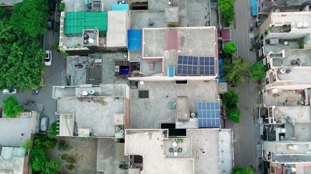 Aerial view of residential rooftops and solar panels in New Delhi, India.