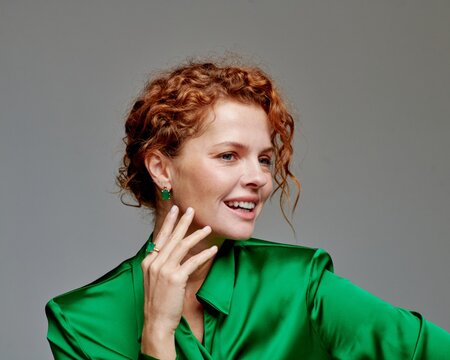 Elegant Woman with Red Hair Wearing Green Silk Blouse and Fashionable Jewelry Accessory