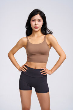 Athletic woman in yoga wear against a pure white background