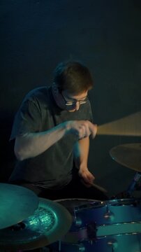 Concentrated drummer perfecting delicate boundaries on drums and cymbals