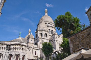 Sacre-Coeur Basilica white dome and turrets framed by ivy-covered walls, Paris © Moiseii Production