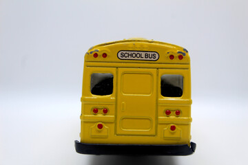 Back view of yellow school toy bus isolated on white background back to school concept  © Yousra Saleh 