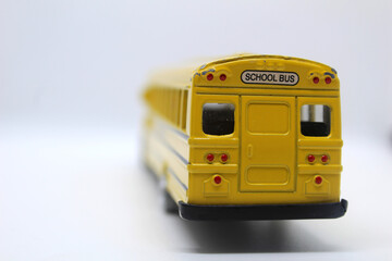 Back view of yellow school toy bus isolated on white background back to school concept  © Yousra Saleh 