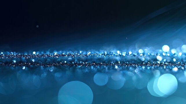 Dark blue abstract bokeh and glittering light streaks on black
