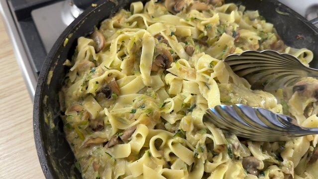 Golden baked pasta dish; appears creamy and savory; perfect for a comforting family meal or gathering; rich texture and inviting presentation