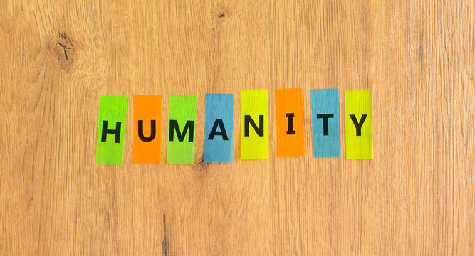 Humanity word symbol. Concept word Humanity on beautiful colored papers. Beautiful wooden background. Business support help humanity word concept. Copy space.