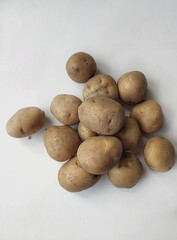 Fototapeta premium Fresh raw potatoes arranged on a clean white background, showcasing natural organic vegetables, healthy food ingredients, and rustic farm produce.