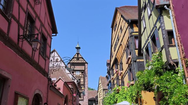 Picturesque alley with traditional alsatian half timbered houses and the Butchers' Tower in Ribeauville, a famous village in Alsace