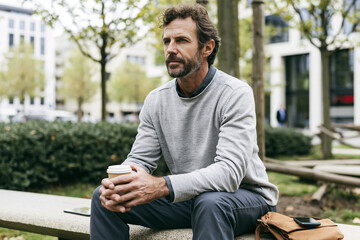 Fototapeta premium young man sitting on bench