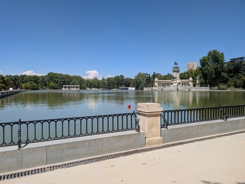 Scenic view across the Great Lake of El Retiro Park in Madrid, Spain, towards the Monument to Alfonso XII. The historic equestrian monument stands prominently on the opposite shore. 