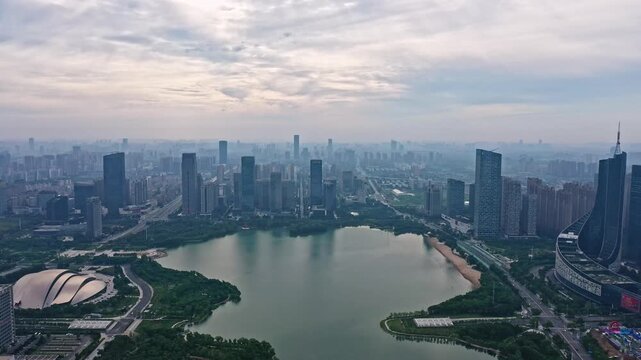 Aerial view of Hefei Swan Lake CBD, modern urban skyline with skyscrapers and lake at cloudy sunset, Anhui, China