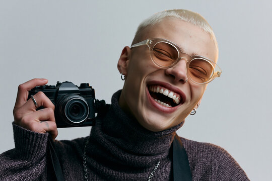 Trendy Young Man Laughing While Holding Vintage Camera