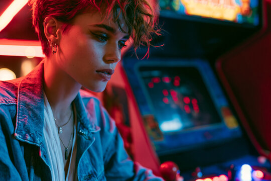Young Woman Playing Vintage Arcade Game Under Neon Lights
