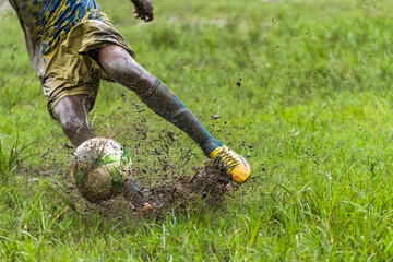 Boy kicking soccer ball in rainy season © suman