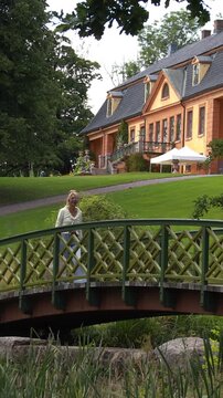 Woman on a bridge in the park. Vertical design in 9:16 ratio. Smartphone and social media ready.