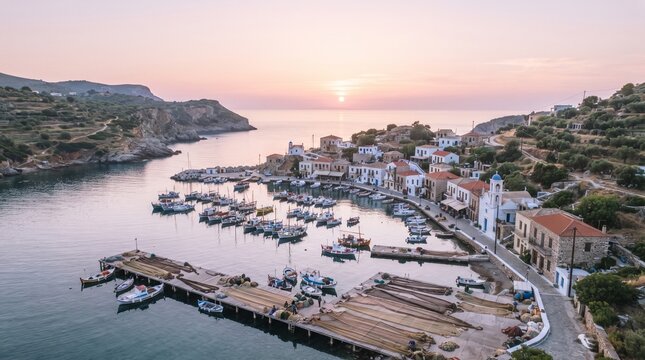Beautiful Greek fishing village and picturesque harbor at sunset with traditional white houses and moored boats.