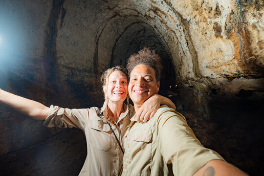 Smiling couple take selfie inside Galapagos Islands cave