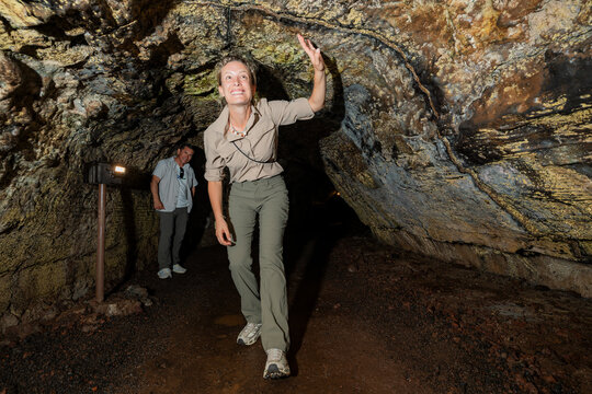 Tourist explore lava tunnel in Galapagos Islands, Ecuador