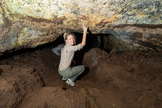 Woman explore lava tunnel cave in the Galapagos Islands