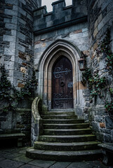 Fototapeta premium Heavy medieval wooden door and stone steps of castle