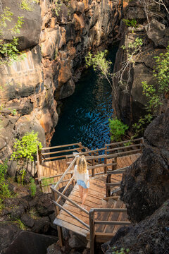 Woman descend staircase to volcanic gorge in Galapagos