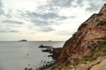 Fototapeta premium Rocky Coastline and Sea Bay Under Cloudy Sky