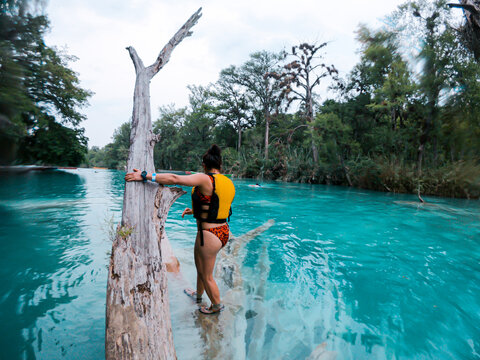 Woman stands waist-deep in vivid turquoise water