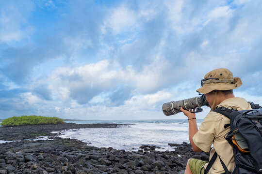 Wildlife photographer on volcanic coast of Galapagos Islands