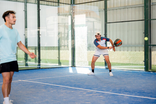 Padel doubles players compete during an indoor tournament match