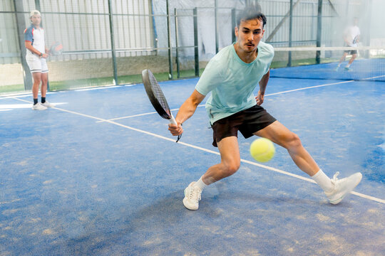 Padel player return ball during doubles tournament match