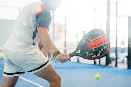 Padel player prepares forehand shot during indoor tournament