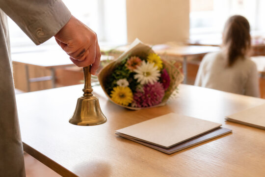 Teacher Ringing Traditional School Bell at Start of Classroom Lessons