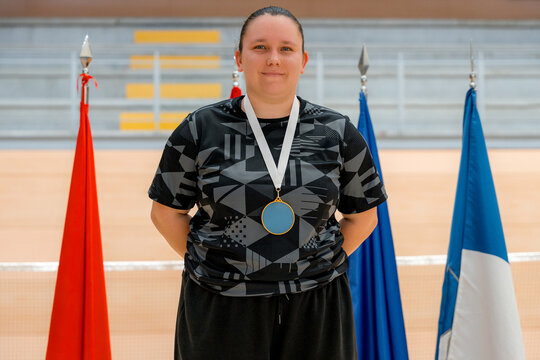 Woman badminton tournament medalist posing with flags