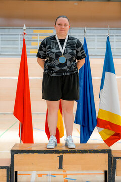 Woman badminton champion on podium with medal and flag