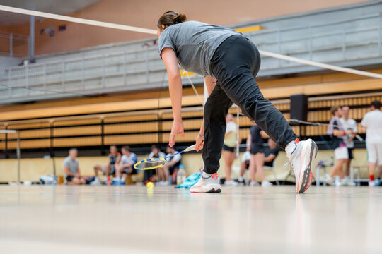 Woman compete in indoor badminton tournament match