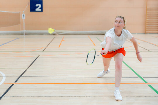 Woman compete in badminton tournament on indoor court