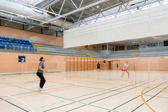 Women compete in badminton tournament at indoor sports hall
