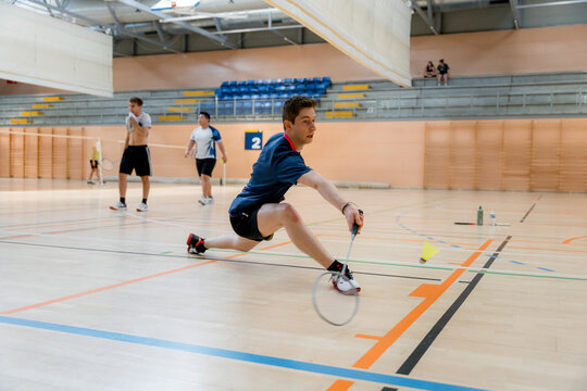 Male player reach for shuttlecock at badminton tournament