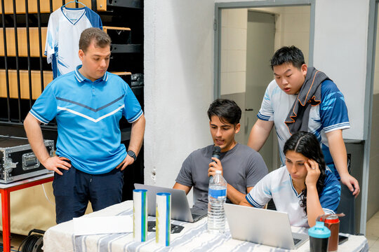 Badminton tournament officials review match data at laptop