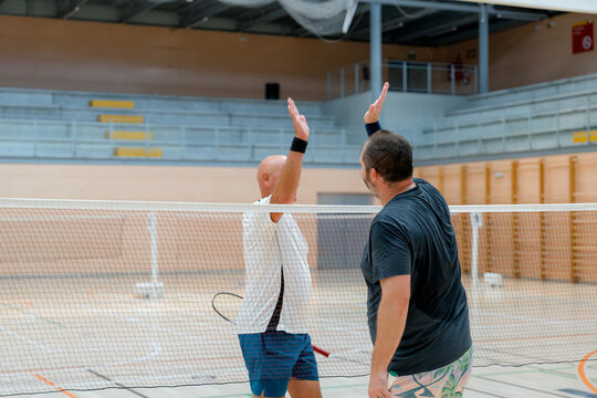 Badminton players show fair play after indoor match
