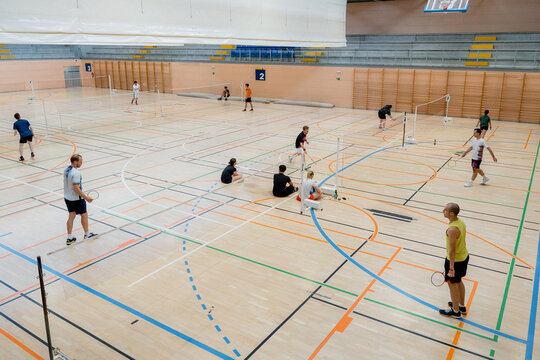 Badminton tournament players compete in indoor sports hall