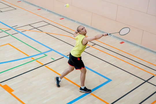Badminton player hit shuttlecock during indoor tournament match